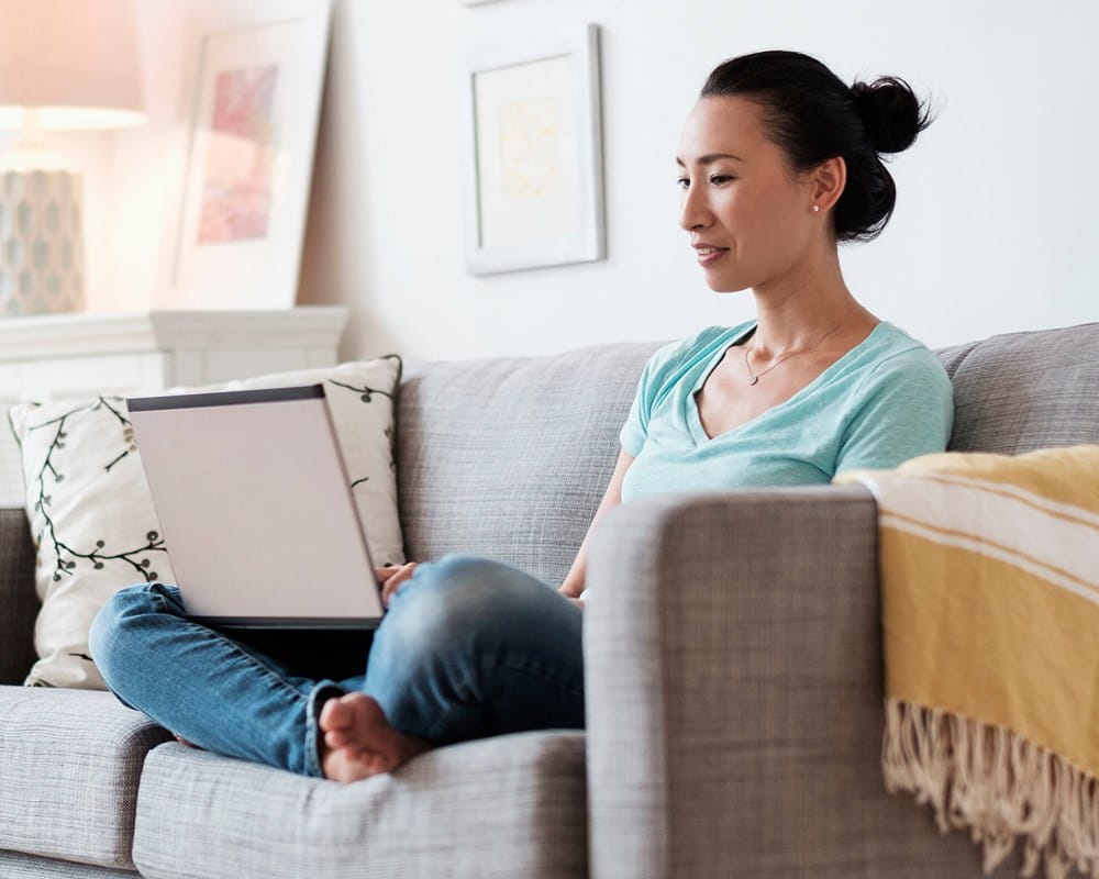 Woman using laptop on sofa