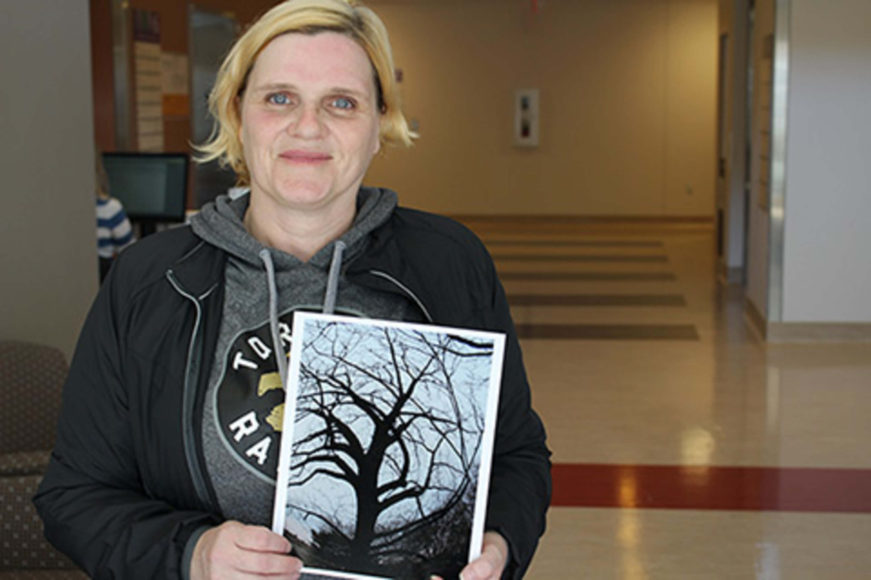 CAMH client Christine holds photograph she took that was selected for photo exhibit