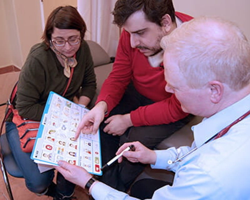 A clinician showing his patient and caregiver the Health Check toolkit