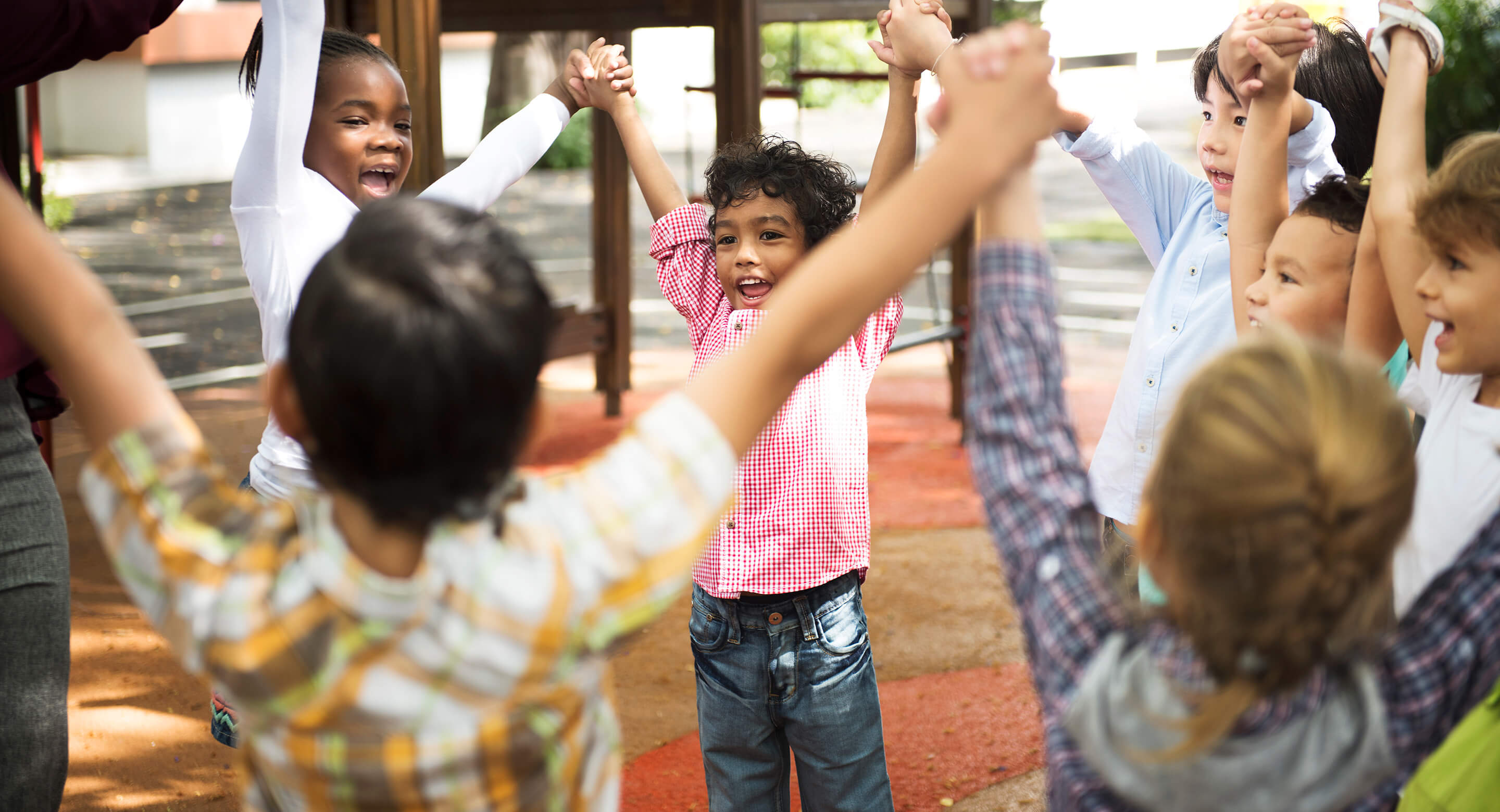 Kindergarten students holding hands in a circle.