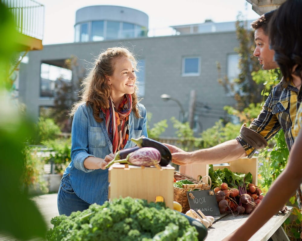 Couple talking to vendor at community Farmers Market.
