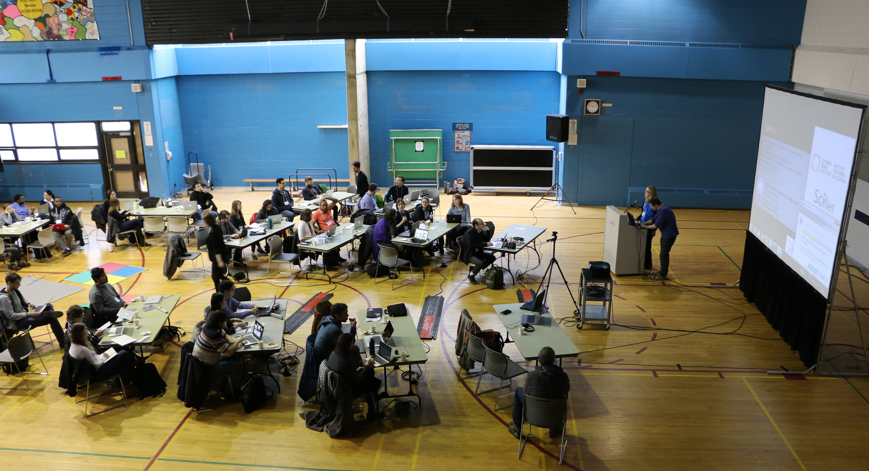 Conference attendees sitting in gymnasium while taking part in CAMH's BrainHack Toronto event