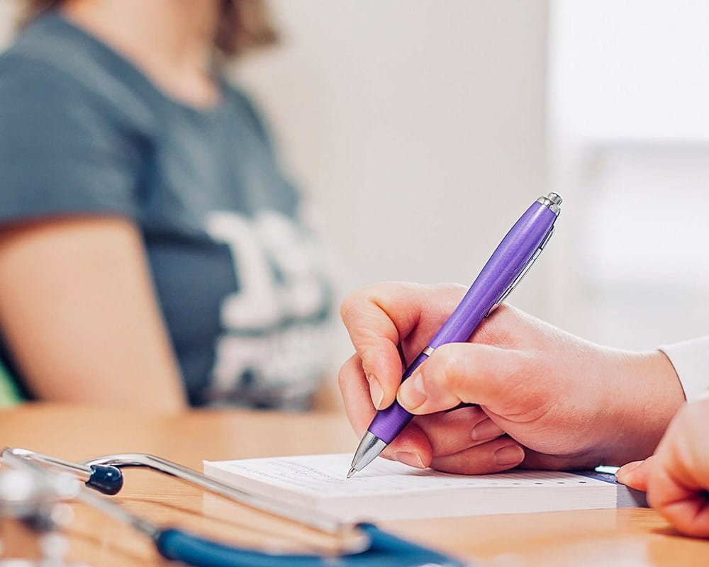 Doctor writing with purple pen