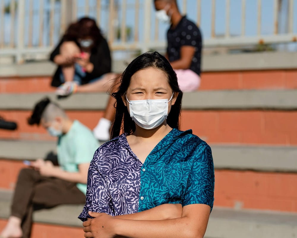Worried teen girl wearing a mask