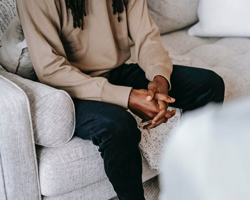 Person sitting on couch talking to person across from them