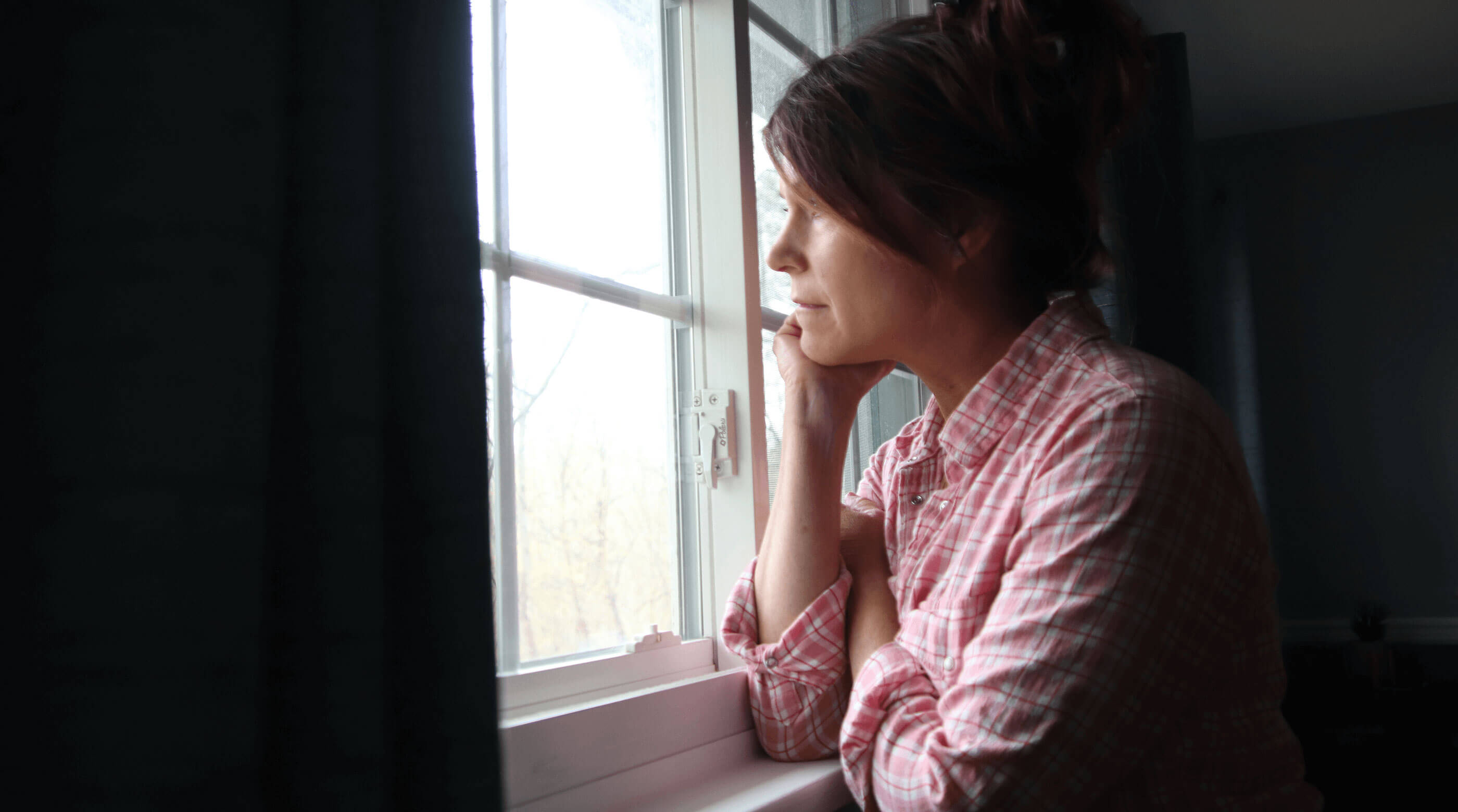 Sad woman looking out window