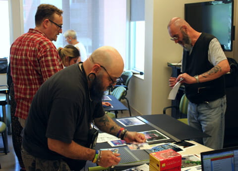 Sean (left) helps David and Peter arrange their displays in preparation for the show 