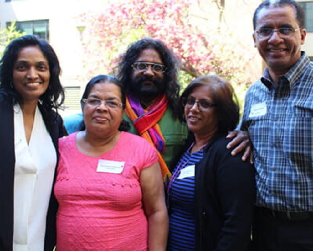 A group of South Asians standing together outside smiling at the camera