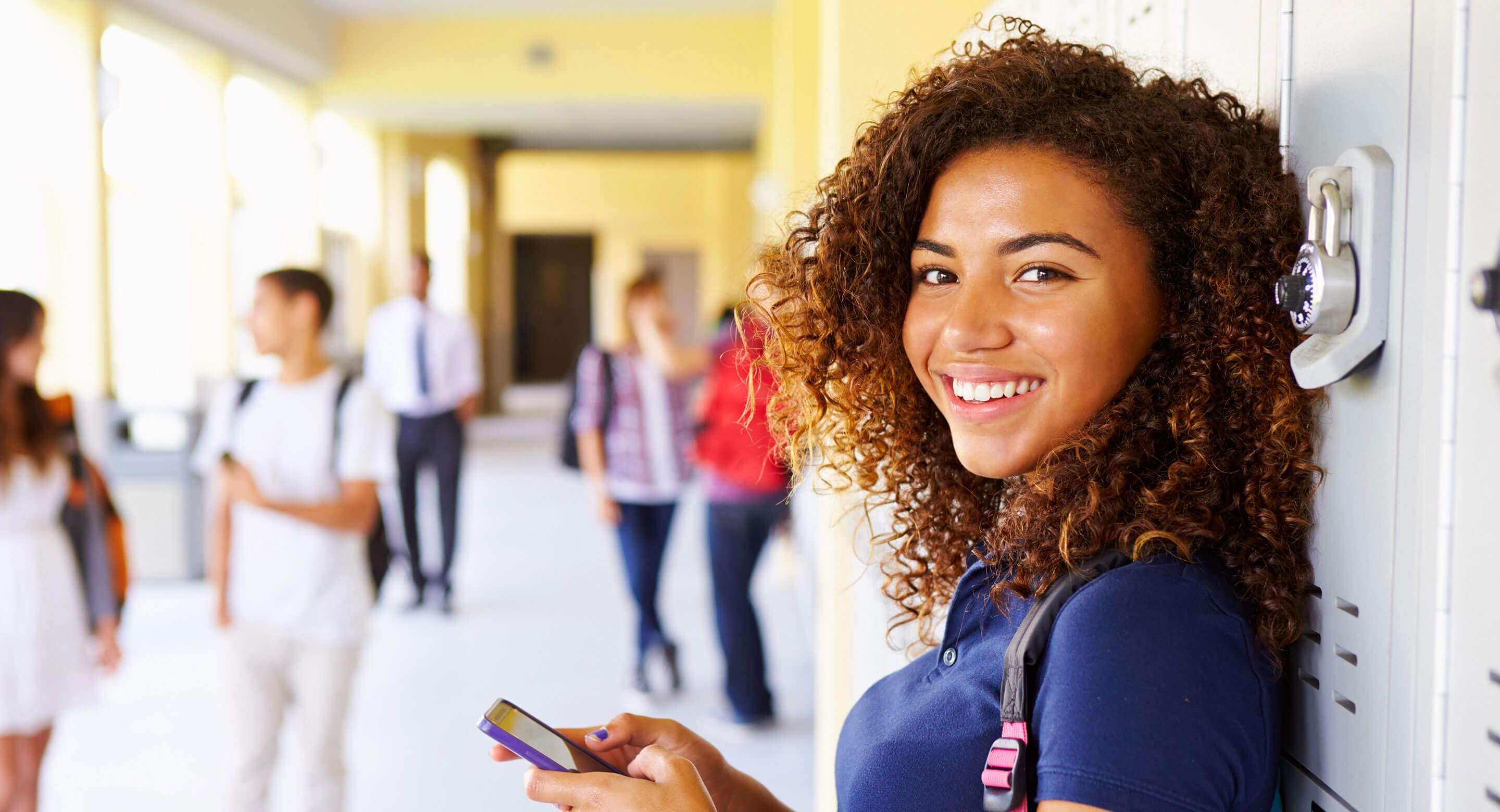 Teenage girl standing in school hallway