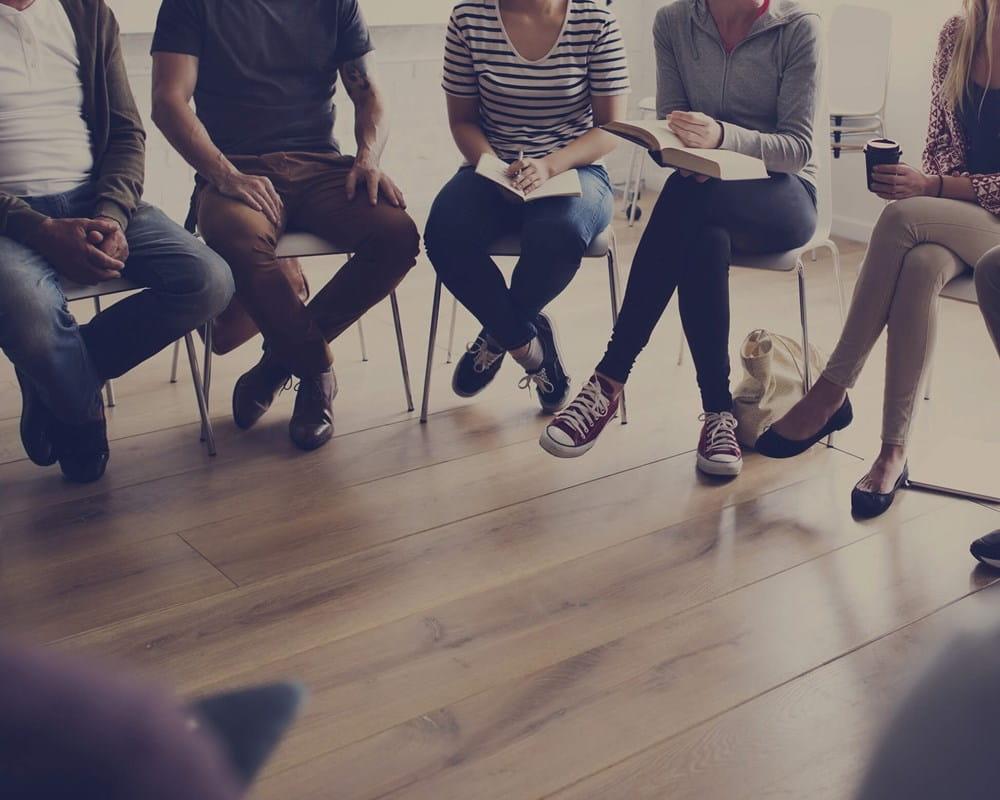 People sitting in a semi-circle with only their legs visible