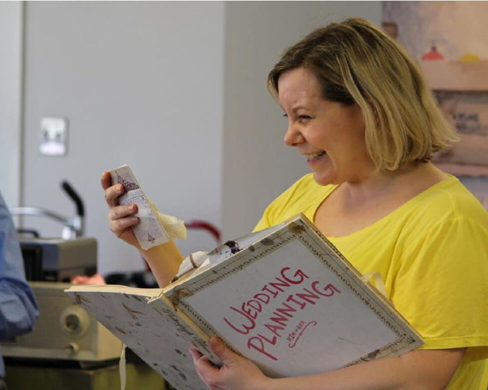 Man singing and woman reading from a book at Smile Serenades