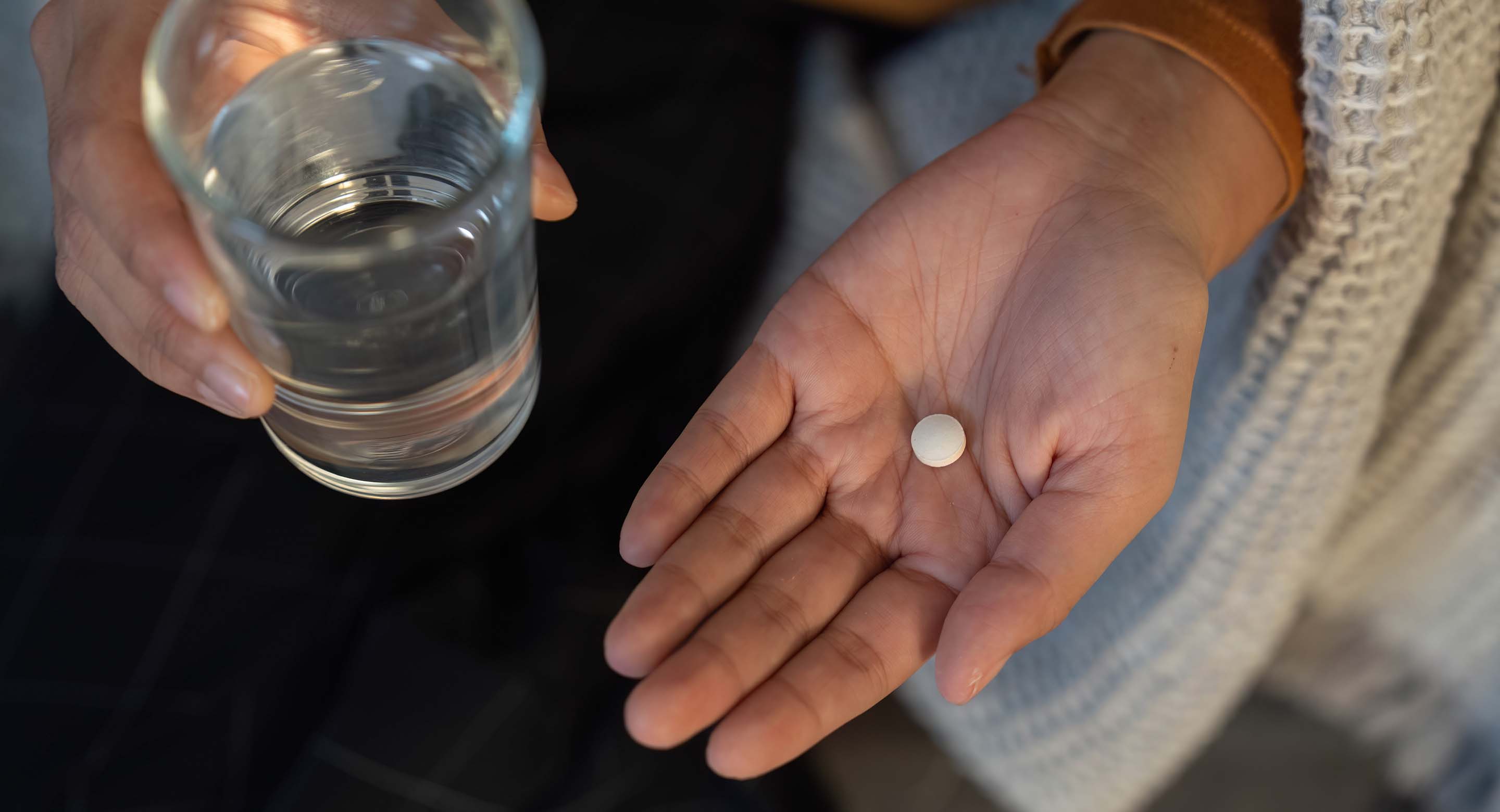 A person prepares to take a pill
