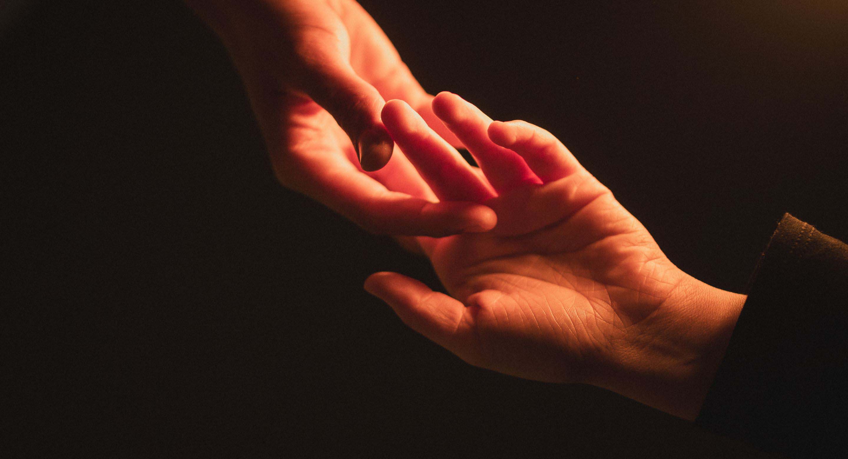 One hand reaching for another