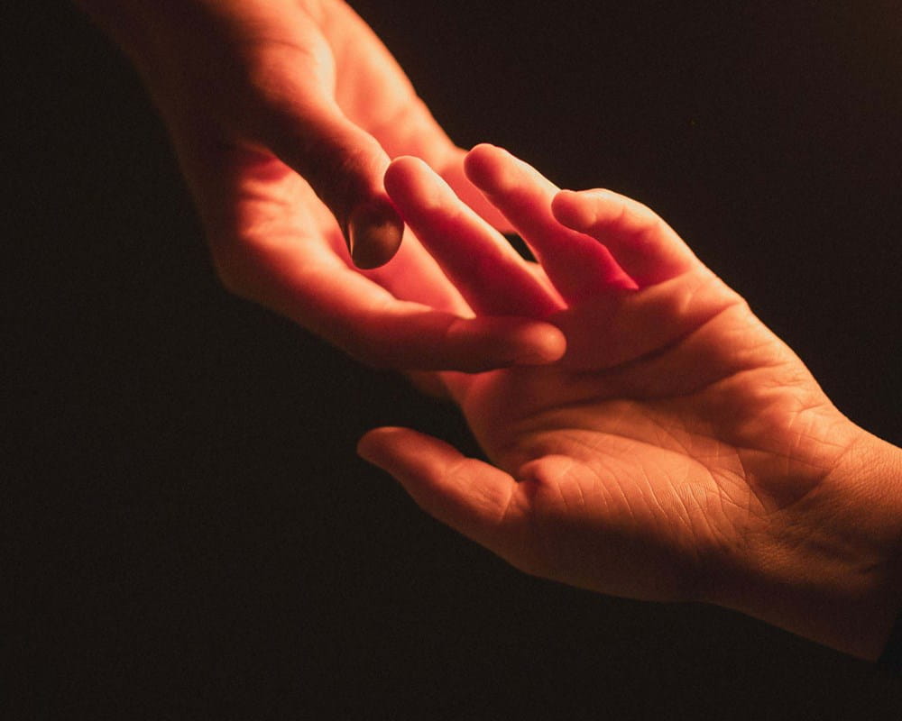 One hand reaching for another