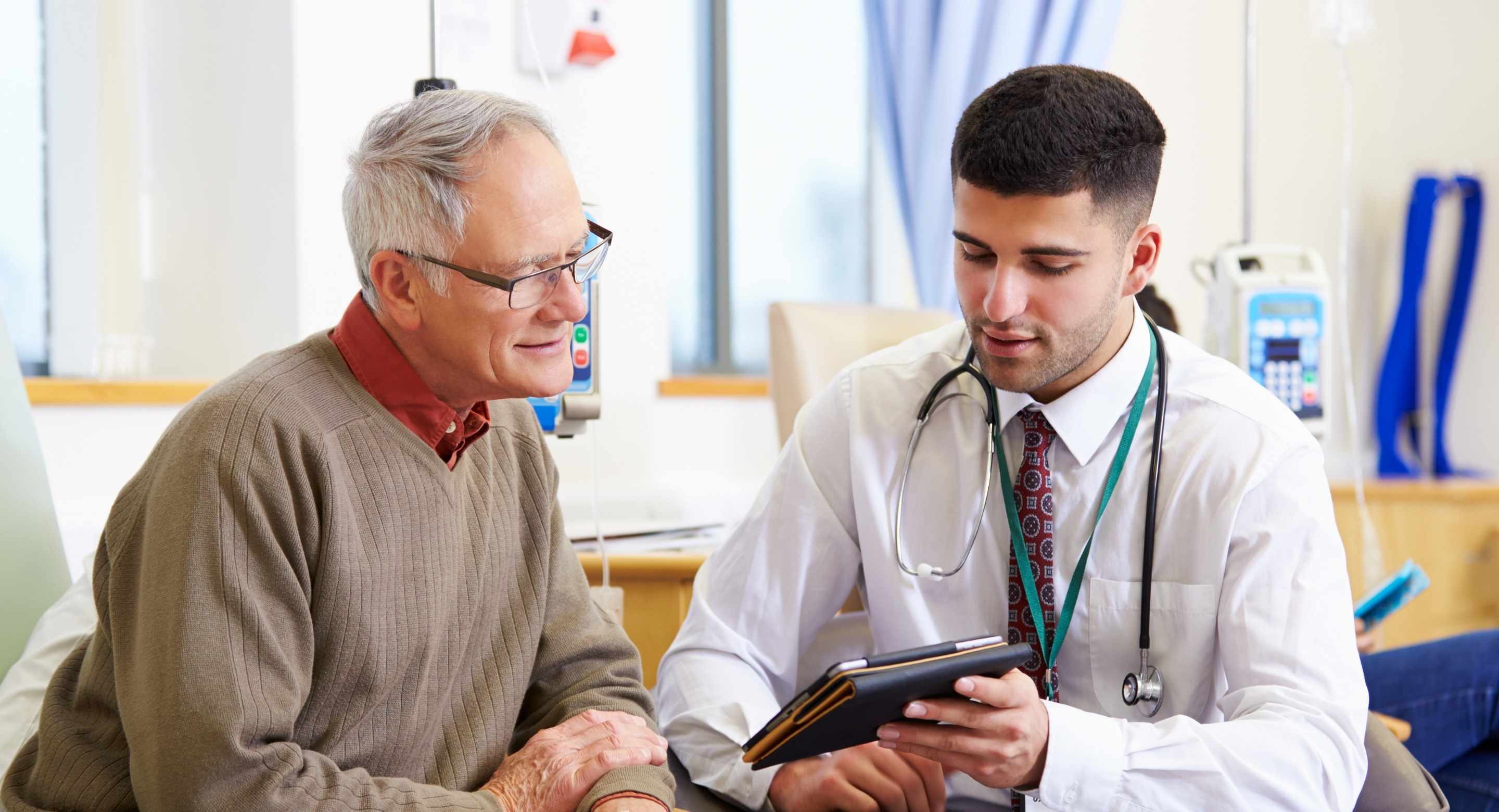 Doctor speaking to a patient while looking at a tablet