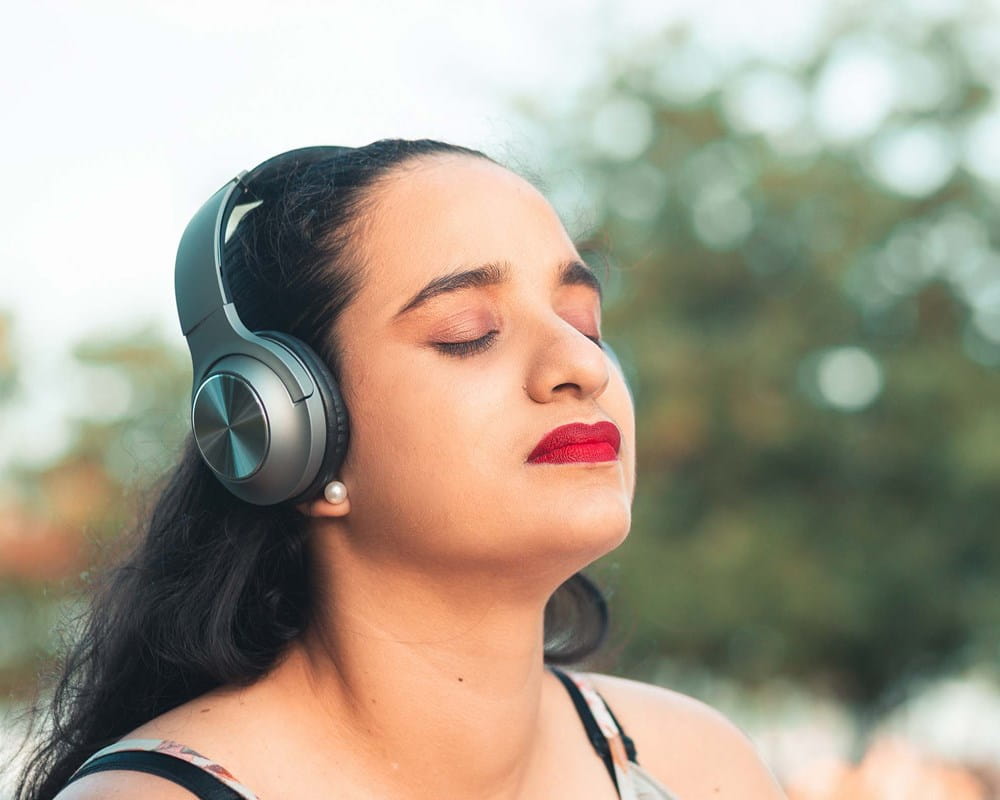 Woman listening to music outdoors on headphones